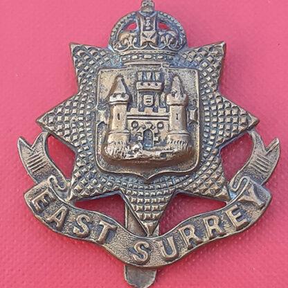 The East Surrey Regiment - King's Crown WW1 Economy Issue Gilding Metal Cap Badge.