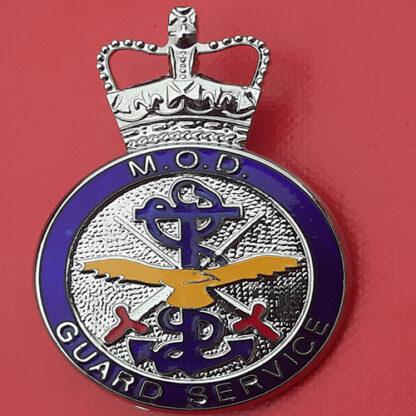 M.O.D Guard Service - Queen's Crown Enamelled Metal Cap Badge.
