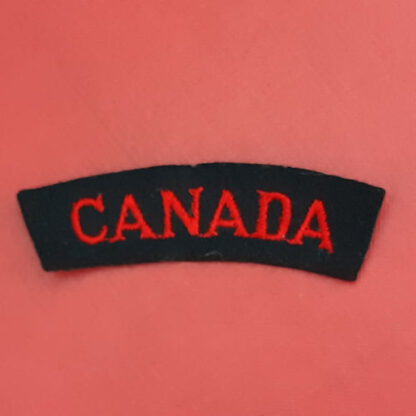 (Canada) - Red On Black Cloth Nationality Badge.